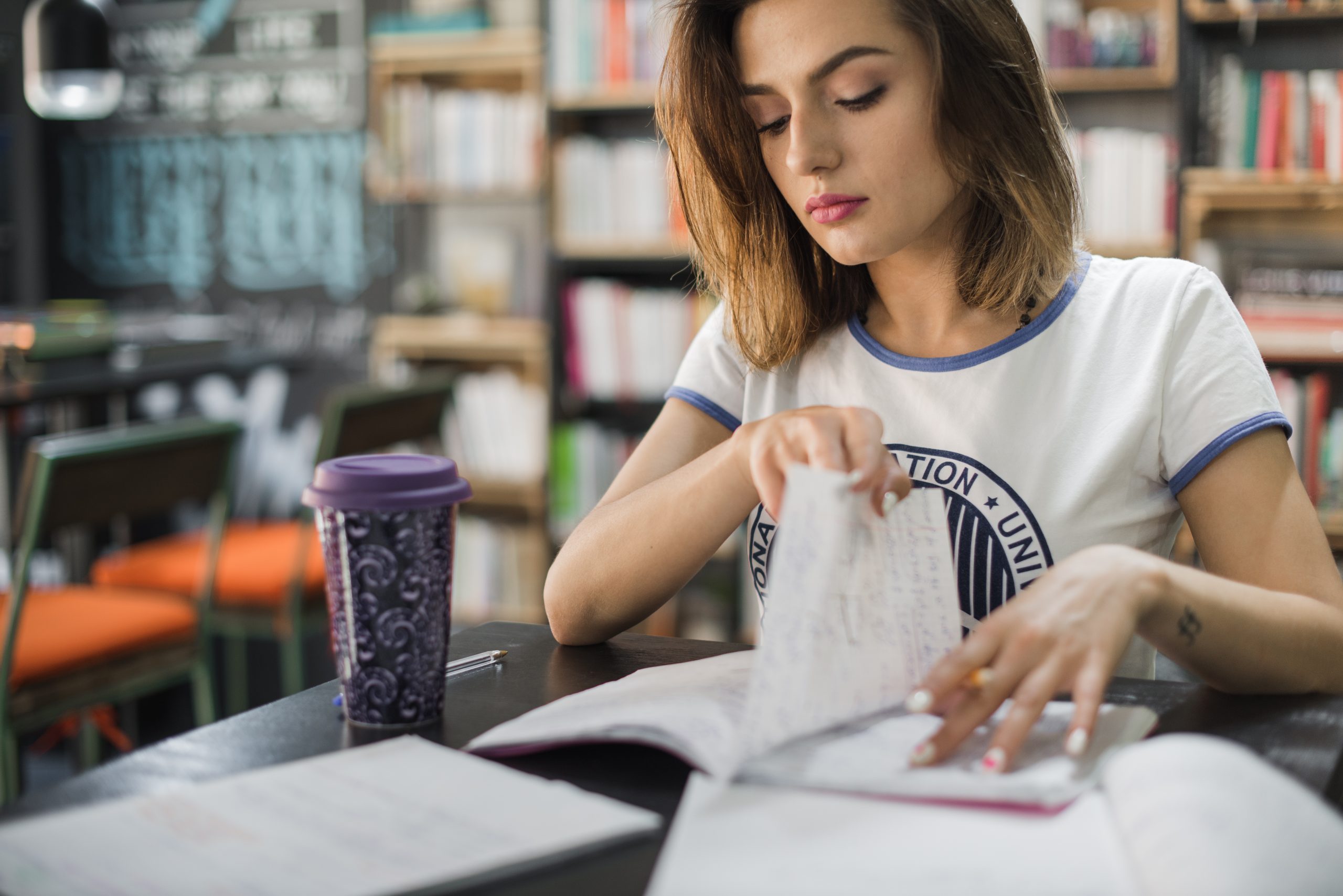 chica-sentada-la-lectura-de-la-tabla-moviendo-la-pagina