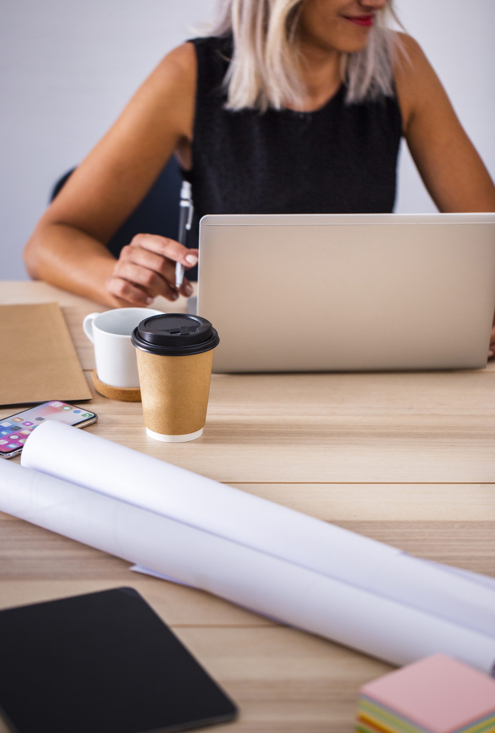 mujer-de-angulo-bajo-en-la-oficina-trabajando-en-la-computadora-portatil